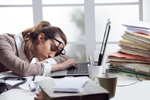 Image of Tired businesswoman sleeping on the desk, in front of the computer screen.